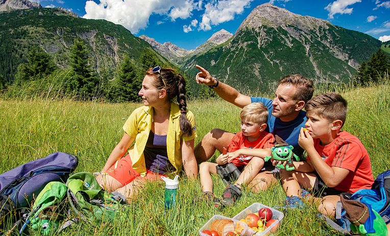 familie-bei-der-wanderpause-auf-der-bergwiese